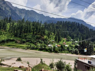 Kaşmir 'deki Neelum Vadisi' nin göz kamaştırıcı gündüz manzarası. Kaşmir 'deki Neelum Vadisi nefes kesici bir yerdir. Bereketli yeşil manzarası, uzun ağaçları ve canlı yeşilliği cennete benzer bir manzara yaratır..