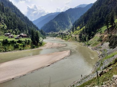 Kaşmir 'deki Neelum Vadisi' nin göz kamaştırıcı gündüz manzarası. Kaşmir 'deki Neelum Vadisi nefes kesici bir yerdir. Bereketli yeşil manzarası, uzun ağaçları ve canlı yeşilliği cennete benzer bir manzara yaratır..