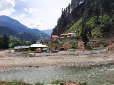 Kaşmir 'deki Neelum Vadisi' nin göz kamaştırıcı gündüz manzarası. Kaşmir 'deki Neelum Vadisi nefes kesici bir yerdir. Bereketli yeşil manzarası, uzun ağaçları ve canlı yeşilliği cennete benzer bir manzara yaratır..