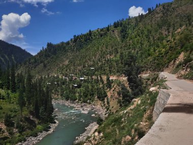 Kaşmir 'deki Neelum Vadisi' nin göz kamaştırıcı gündüz manzarası. Kaşmir 'deki Neelum Vadisi nefes kesici bir yerdir. Bereketli yeşil manzarası, uzun ağaçları ve canlı yeşilliği cennete benzer bir manzara yaratır..