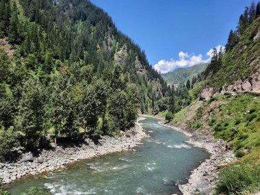 Kaşmir 'deki Neelum Vadisi' nin göz kamaştırıcı gündüz manzarası. Kaşmir 'deki Neelum Vadisi nefes kesici bir yerdir. Bereketli yeşil manzarası, uzun ağaçları ve canlı yeşilliği cennete benzer bir manzara yaratır..