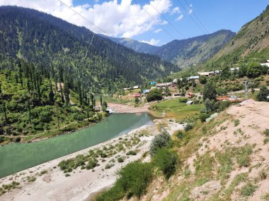 Kaşmir 'deki Neelum Vadisi' nin göz kamaştırıcı gündüz manzarası. Kaşmir 'deki Neelum Vadisi nefes kesici bir yerdir. Bereketli yeşil manzarası, uzun ağaçları ve canlı yeşilliği cennete benzer bir manzara yaratır..