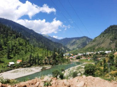 Kaşmir 'deki Neelum Vadisi' nin göz kamaştırıcı gündüz manzarası. Kaşmir 'deki Neelum Vadisi nefes kesici bir yerdir. Bereketli yeşil manzarası, uzun ağaçları ve canlı yeşilliği cennete benzer bir manzara yaratır..
