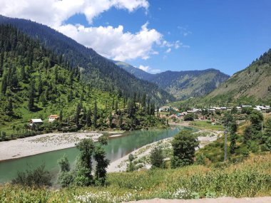 Kaşmir 'deki Neelum Vadisi' nin göz kamaştırıcı gündüz manzarası. Kaşmir 'deki Neelum Vadisi nefes kesici bir yerdir. Bereketli yeşil manzarası, uzun ağaçları ve canlı yeşilliği cennete benzer bir manzara yaratır..