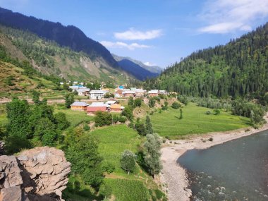Kaşmir 'deki Neelum Vadisi' nin göz kamaştırıcı gündüz manzarası. Kaşmir 'deki Neelum Vadisi nefes kesici bir yerdir. Bereketli yeşil manzarası, uzun ağaçları ve canlı yeşilliği cennete benzer bir manzara yaratır..