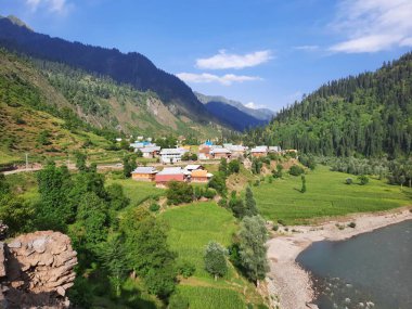 Kaşmir 'deki Neelum Vadisi' nin göz kamaştırıcı gündüz manzarası. Kaşmir 'deki Neelum Vadisi nefes kesici bir yerdir. Bereketli yeşil manzarası, uzun ağaçları ve canlı yeşilliği cennete benzer bir manzara yaratır..