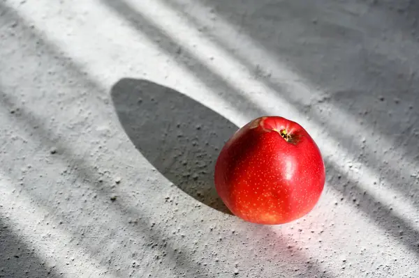 Ήλιος Λάμπει Ένα Κόκκινο Μήλο Που Βρίσκεται Στο Τραπέζι — Φωτογραφία Αρχείου