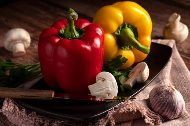 Mantarlar, kırmızı ve sarı biberler mutfaktaki masanın üzerinde. 