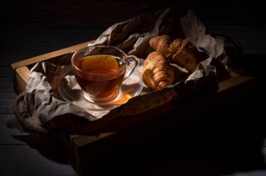 Evening tea and croissants on the table in the kitchen 