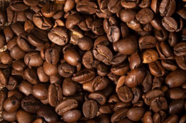 Coffee beans spilled out of the cup on the table in the kitchen 