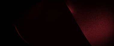 Kırmızı bir kumaşın yakın çekimi, ışık onun dokusunu kurnazca vurgular ve soyut, neredeyse sanatsal bir kompozisyon yaratır..