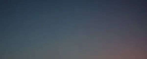 Alacakaranlık gökyüzünün büyüleyici bir görüntüsü, pürüzsüz bir mavi ve pembe gradyanı var. Huzurlu ve huzurlu.