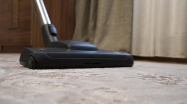 Modern apartmandaki elektrik süpürgesinin kapağını kapatın. Oturma odasında evi düzenli tutacak bir kadın. Ev temizliği ve ev işi konsepti. Yüksek kalite 4k görüntü
