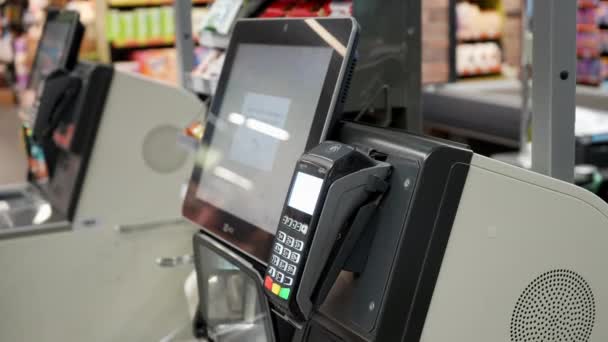スーパーマーケットで チェックアウトカウンター顧客はスマートフォンで支払います 大型ショッピングモール 小線と現代のワイヤレス支払いターミナルシステム 高品質4K映像 — ストック動画