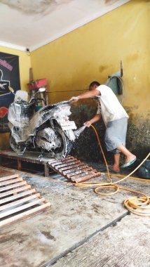 Bandung, Endonezya - 18 Kasım 2022: Motosikletler bir motosiklet yıkama servisinde sabunlu suyla kaplandı