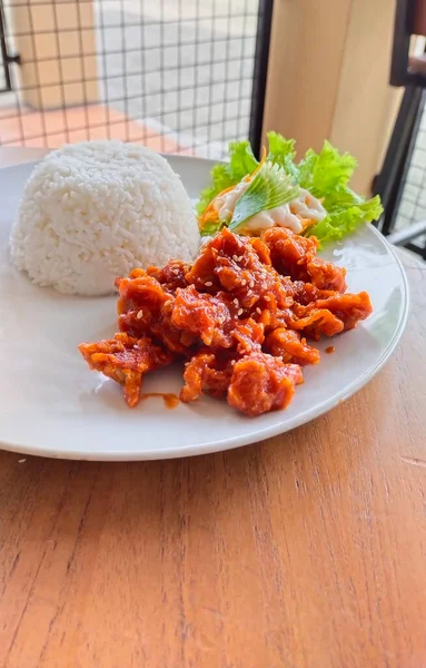 Bir tabak ev yapımı Kore yemeği 'Dakganjeong' (tatlı ve baharatlı Kore kızarmış tavuğu), beyaz pirinç ve salatayla servis edilir.
