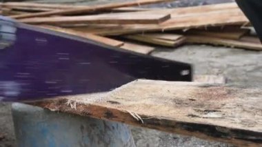 Bir el testeresi kullanarak tahta kesme aktivitesi