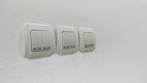 three pairs of light switch panels on a white wall