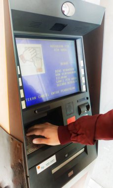 Bandung, Endonezya - 19 Eylül 2023; Bir kişinin eli bir ATM makinesinin düğmesine basıyor