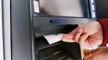 Bandung, Endonezya - 19 Eylül 2023; Bandung, Endonezya - Bir kişinin eli ATM makinesinde başarılı bir şekilde bir e-geçiş ücreti doldurduktan sonra bir kağıt makbuz alır