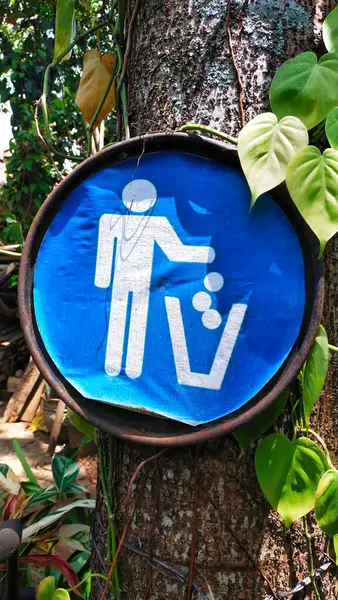 icon design about the appeal to throw away rubbish in a rubbish bin tied to a tree trunk