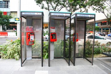 Singapur-14 Ocak 2011; Singapur 'da bir sokakta kart kullanan bir sıra telefon kulübesi