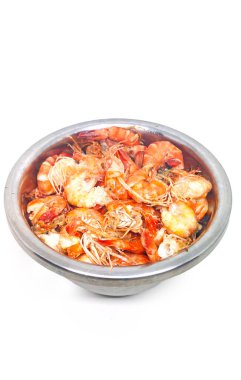 Beyaz arka planda paslanmaz çelikten bir kasede yarı pişmiş karides.