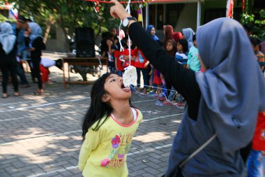 Bandung, Endonezya - 17 Ağustos 2019: Çocukların katıldığı kraker yeme yarışması. Bu, Endonezya 'nın bağımsızlık gününü kutlamak için düzenlenen yarışmalardan biri.