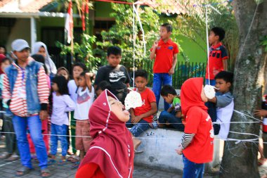 Bandung, Endonezya - 17 Ağustos 2019: Çocukların katıldığı kraker yeme yarışması. Bu, Endonezya 'nın bağımsızlık gününü kutlamak için düzenlenen yarışmalardan biri.