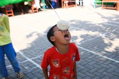 Bandung, Endonezya - 17 Ağustos 2019: Çocukların katıldığı kraker yeme yarışması. Bu, Endonezya 'nın bağımsızlık gününü kutlamak için düzenlenen yarışmalardan biri.