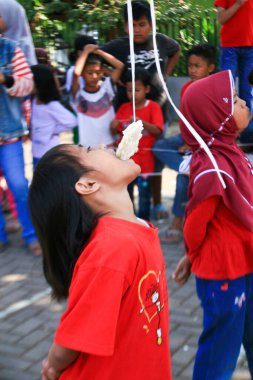 Bandung, Endonezya - 17 Ağustos 2019: Çocukların katıldığı kraker yeme yarışması. Bu, Endonezya 'nın bağımsızlık gününü kutlamak için düzenlenen yarışmalardan biri.