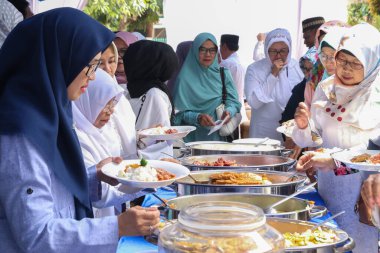 Bandung, Endonezya - 20 Temmuz 2019: Bir grup Shar 'i Müslüman kadın sırayla açık büfe yemekleri yiyor.