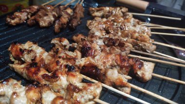 Bandung, Endonezya - 2 Ocak 2024; Ev yapımı tavuk satay ızgara tava kullanılarak kızartılıyor