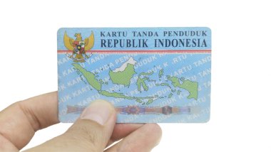 Beyaz bir arkaplanda Endonezya kimlik kartı (KTP) tutan el