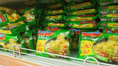 Bandung, Endonezya - 4 Şubat 2024; Soto Mie aromalı Indomie marka hazır şehriye paketleri bir bakkal veya süpermarketin raflarında dizilmiştir.
