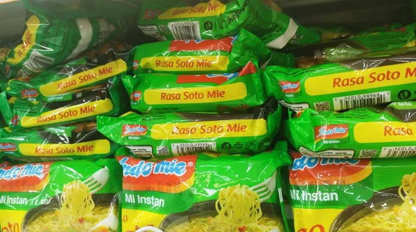 Bandung, Endonezya - 4 Şubat 2024; Soto Mie aromalı Indomie marka hazır şehriye paketleri bir bakkal veya süpermarketin raflarında dizilmiştir.