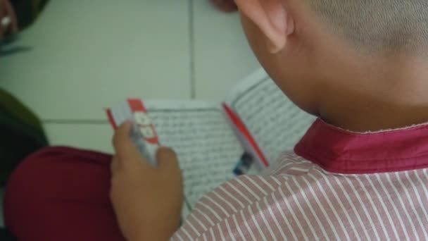 男の子は宗教の授業でコーランを読むことを学ぶ — ストック動画