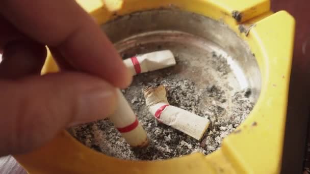 Κλείσε Χέρι Ενός Καπνιστή Και Αρκετά Αποτσίγαρα Ένα Τασάκι — Αρχείο Βίντεο