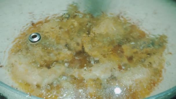 フライドチキンを調理するプロセスは ホットオイルがスパッタリングするのを防ぐために鍋をカバーすることです — ストック動画