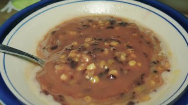 bir kase Bubur Kacang Hijau ve Ketan Hitam (yeşil fasulye lapası ve siyah yapışkan pirinç), yeşil fasulye, hindistan cevizi sütü ve palmiye veya kamış şekerinden yapılan tatlı bir Endonezya lapası.