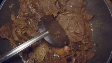 Öğütülmüş sakatat pişirme süreci, tatlı ve ekşi soslu sığır ciğerleri, baharatlar emilene kadar karıştırılarak.