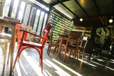 Bandung, Endonezya - 1 Temmuz 2014; Bir kafenin yemek alanı güzel soyut gölgeler oluşturmak için pencere havalandırmasından gelen güneş ışığıyla aydınlatılır.