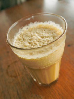 Bir bardak buzlu kahveye yakın çekim. Rüzgarda delikler olan bir frappe ile.