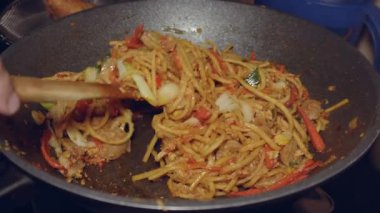 Mie Goreng (kızarmış erişte) pişirme işlemi, tüm elementler eşit karışana kadar karıştırılarak yapılan ev yapımı bir tariftir.
