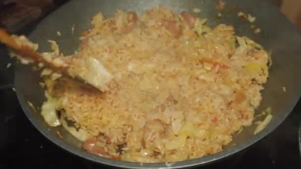 スライスしたソーセージとチョップキャベツ 自家製のレシピでトッピングスパイシーな揚げ米のプロセス — ストック動画