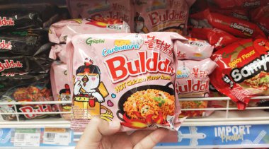 Bandung, Endonezya - 3 Mart 2024; Bir insanın eli Kore baharatlı ramen hazır eriştesini tutuyor