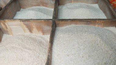 Geleneksel bir pazarda çeşitli fiyatlı ve kaliteli pirinç satılıyor.