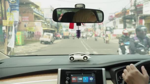 印度尼西亚万隆 2024年4月30日 一名年轻女子在阳光灿烂的日子开车 忙于与行人和其他车辆司机等道路使用者打交道 — 图库视频影像