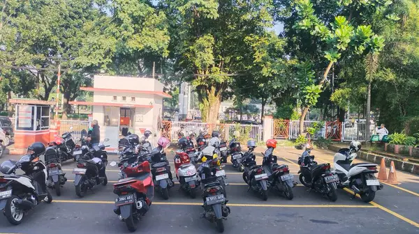Bandung, Endonezya - 15 Mayıs 2024; sabah bir ofis binasının otoparkında sıra sıra motorsikletler