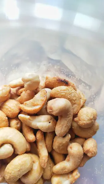 Plastik bir kavanozda kaju fıstığının görüntüsü. Atıştırmalık ya da meze olarak yenebilir.